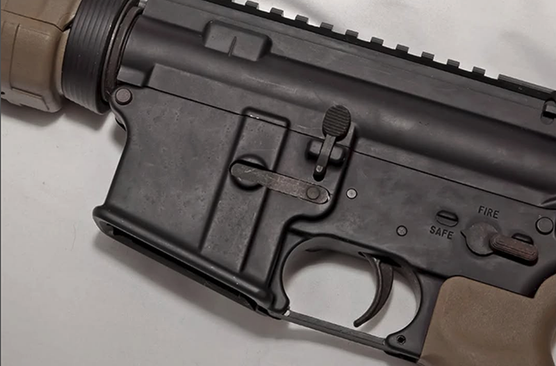 A close-up view of a firearm's action with the safety engaged.
